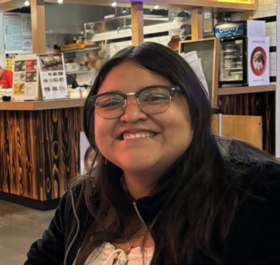 A photograph of Blanca, a smiling Mexican girl with glasses and black hair.